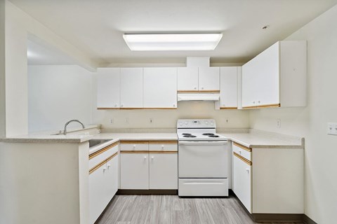 a white kitchen with white appliances and white cabinets